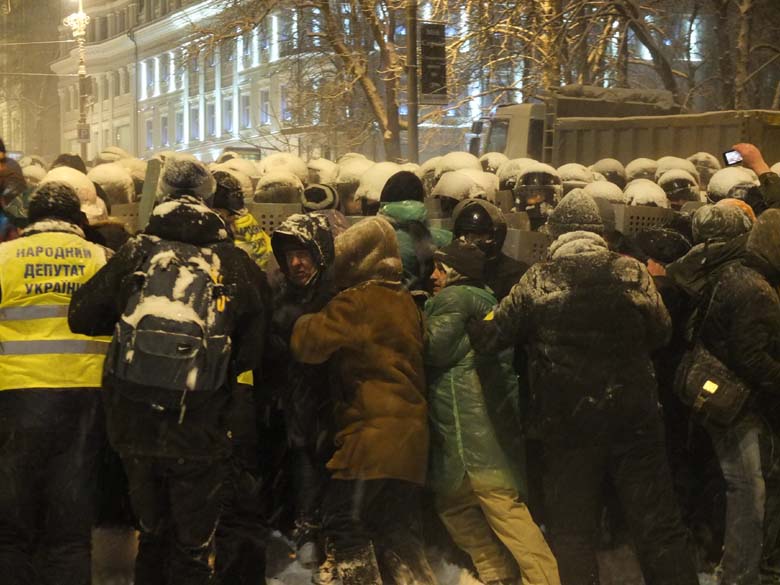 Підрозділ міліції «Беркут» напирає на мітинґувальників, щоб знести барикаду. Фото Петра Андрусечка