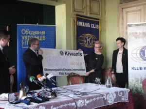 Представник товариства „Kiwanis International ”передає Андрієві Дрозду, директору комплексу українських шкіл в Білому Борі, гроші зі збірки акції «1%». Фото авторки статті